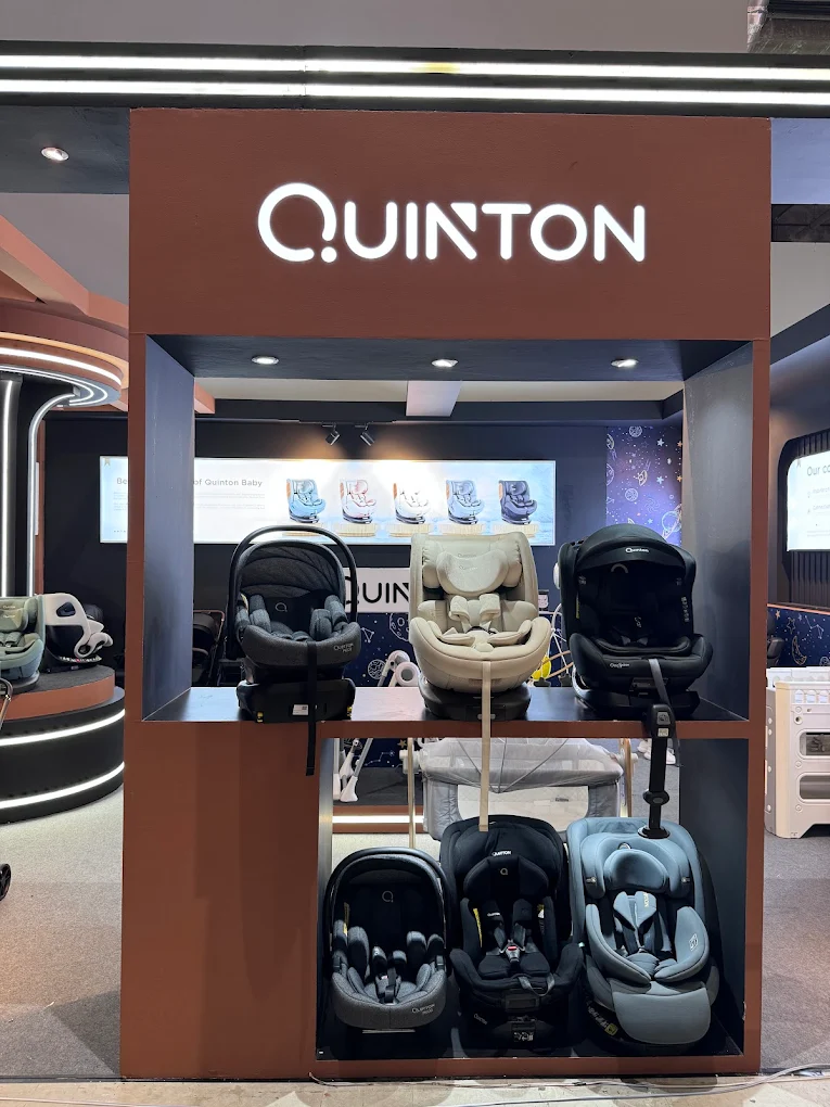 Quinton Baby retail display — illuminated QUINTON logo with JPJ-approved car seats on showroom shelving, Malaysia